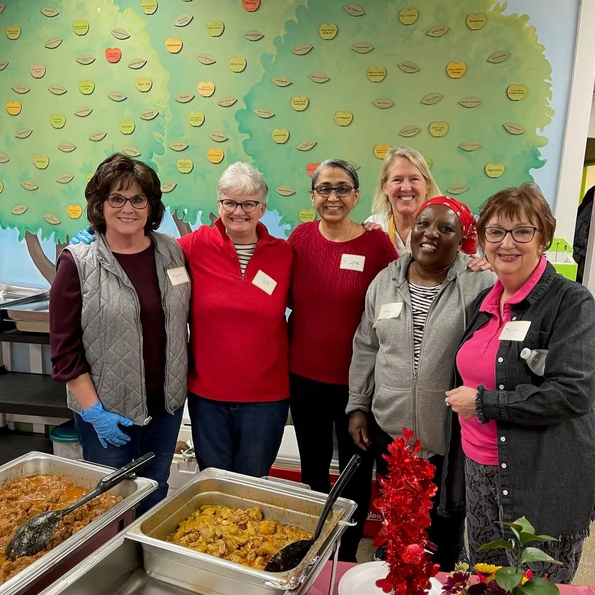 Group of women volunteers serving food at a Green Apple Pantry community event