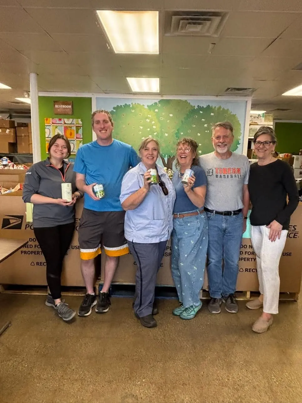 Volunteers and USPS team celebrating a successful food drive at the Green Apple Pantry