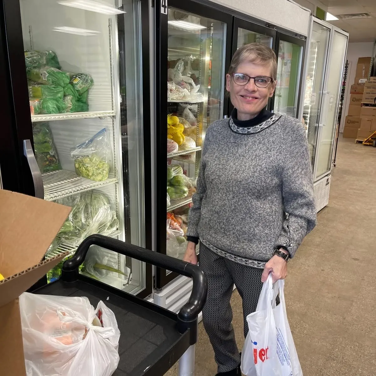 Client selecting fresh produce at the Green Apple Pantry