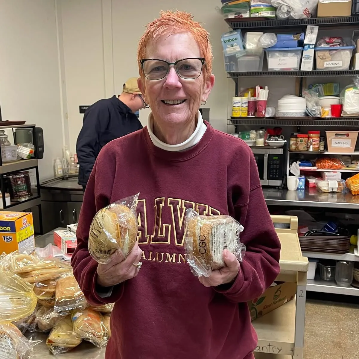Volunteer holding fresh bread at the Green Apple Pantry