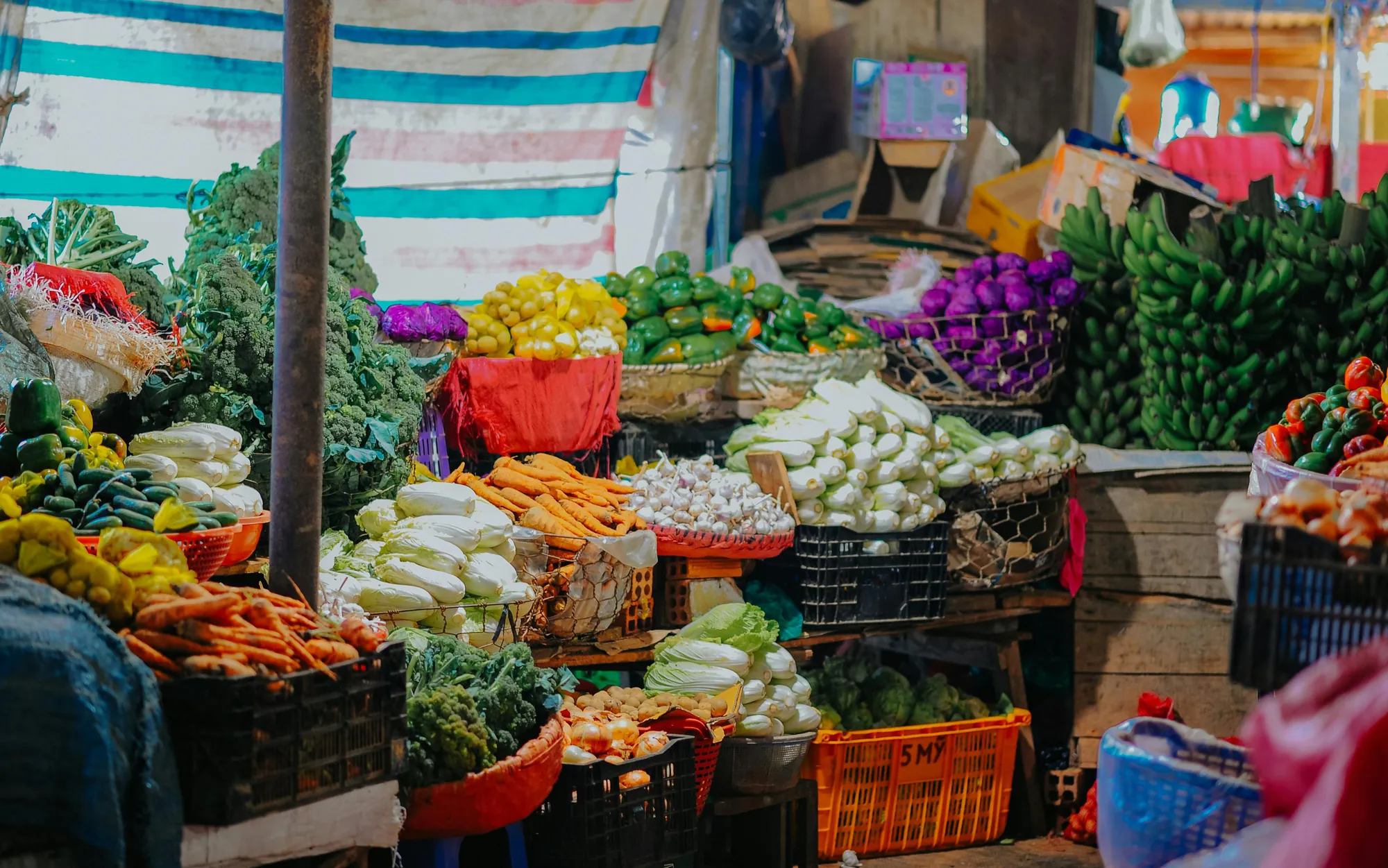Colorful display of fresh fruits and vegetables at a farmers market stall